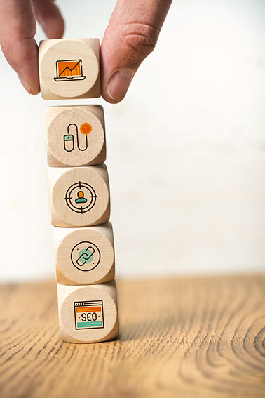 Photo of SEO and user experience process steps, represented as icons on stacked blocks