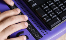 Blind person using computer with braille computer display