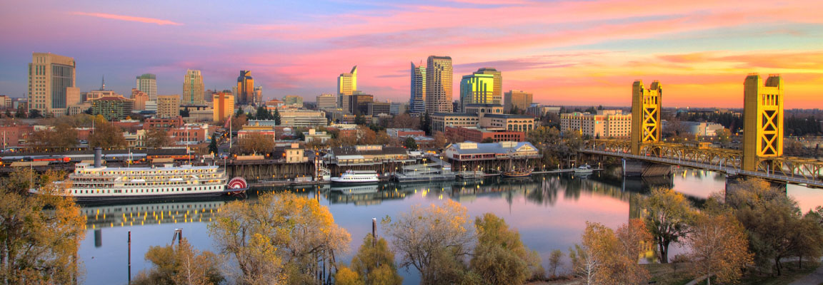 The Sacramento skyline and Tower Bridge at sunset with reflections in the water