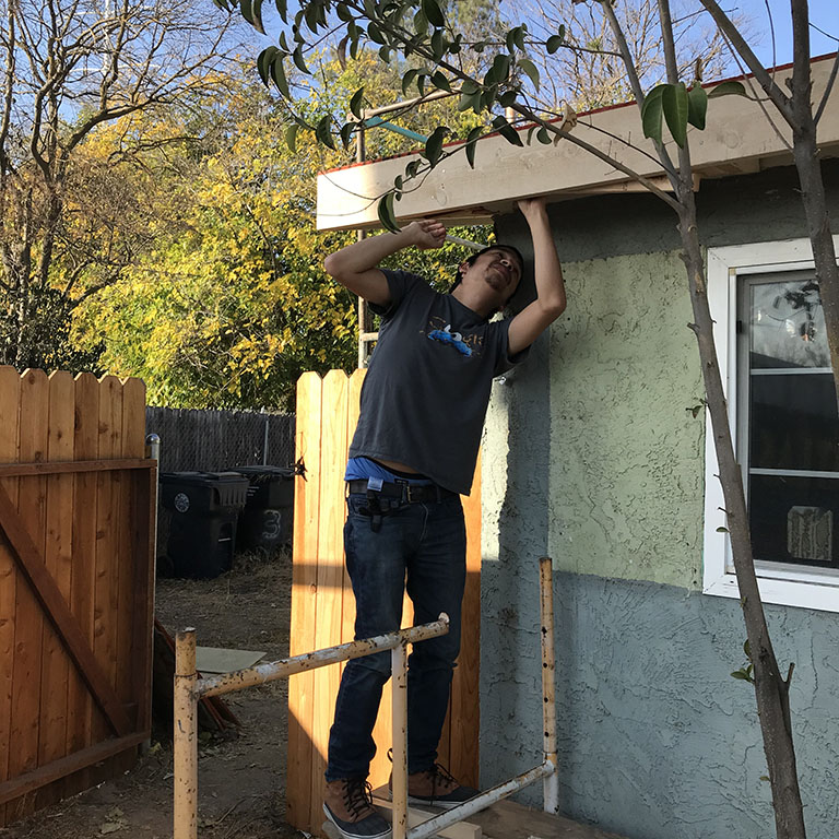 Ben Moulton applying wood to ceiling