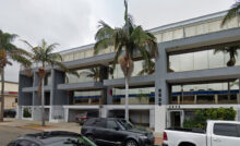 Street view of a gray, two-story office building at 2535 Kettner Blvd in San Diego, CA, with palm trees and parked cars in front.