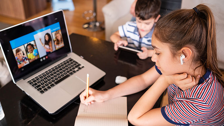 School children participating in online classes using a laptop