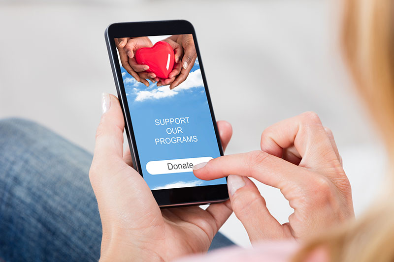 Photo of woman using a mobile app to donate to a non-profit. 